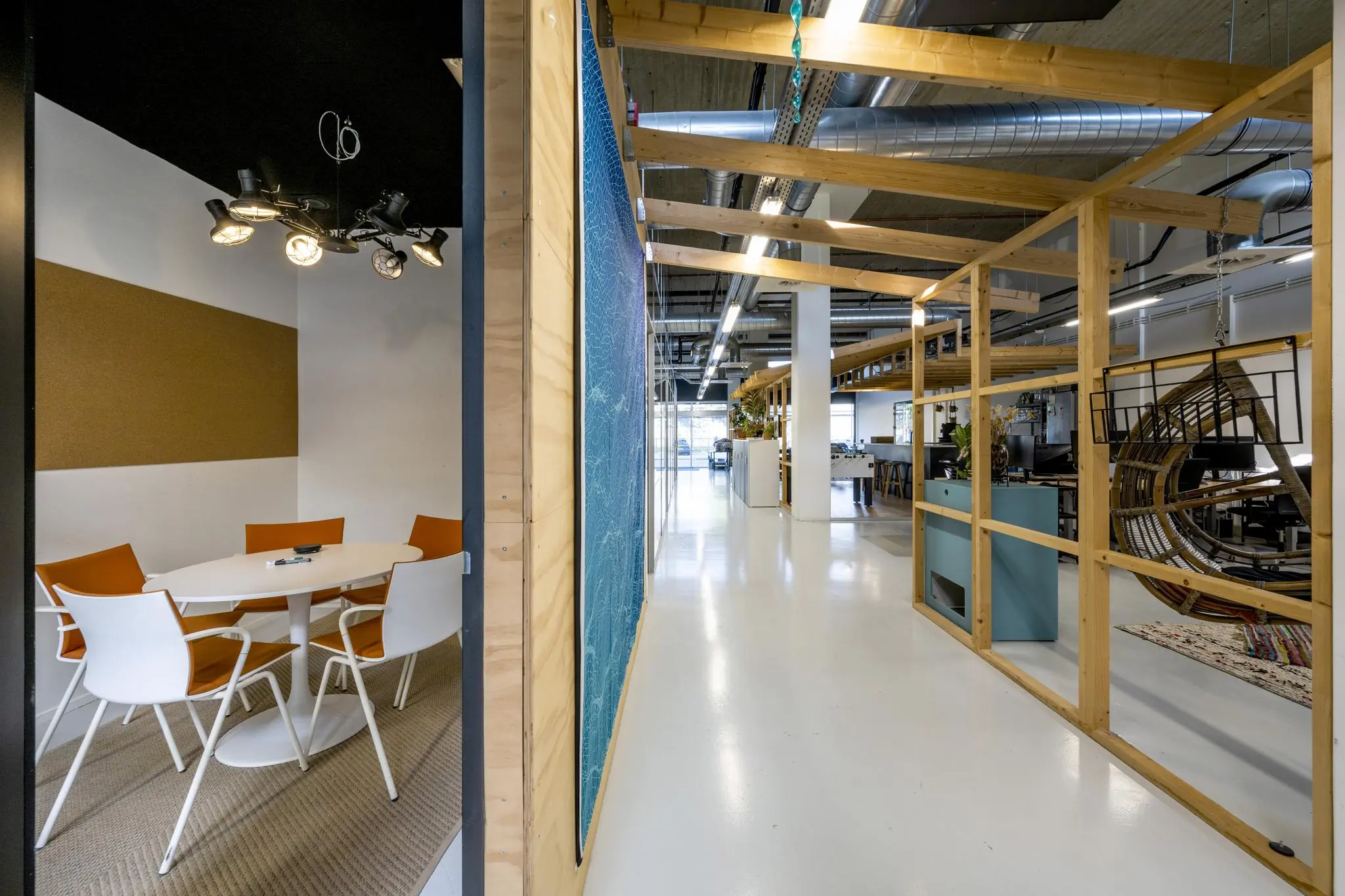 Modern kantoorinterieur aan de Joan Muyskenweg met een vergaderruimte, open werkplekken en houten scheidingswanden.